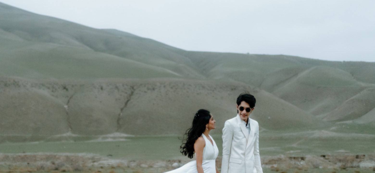 Couple exchanging vows at sunset with Santorini cliffs in the background — BITM destination wedding film.